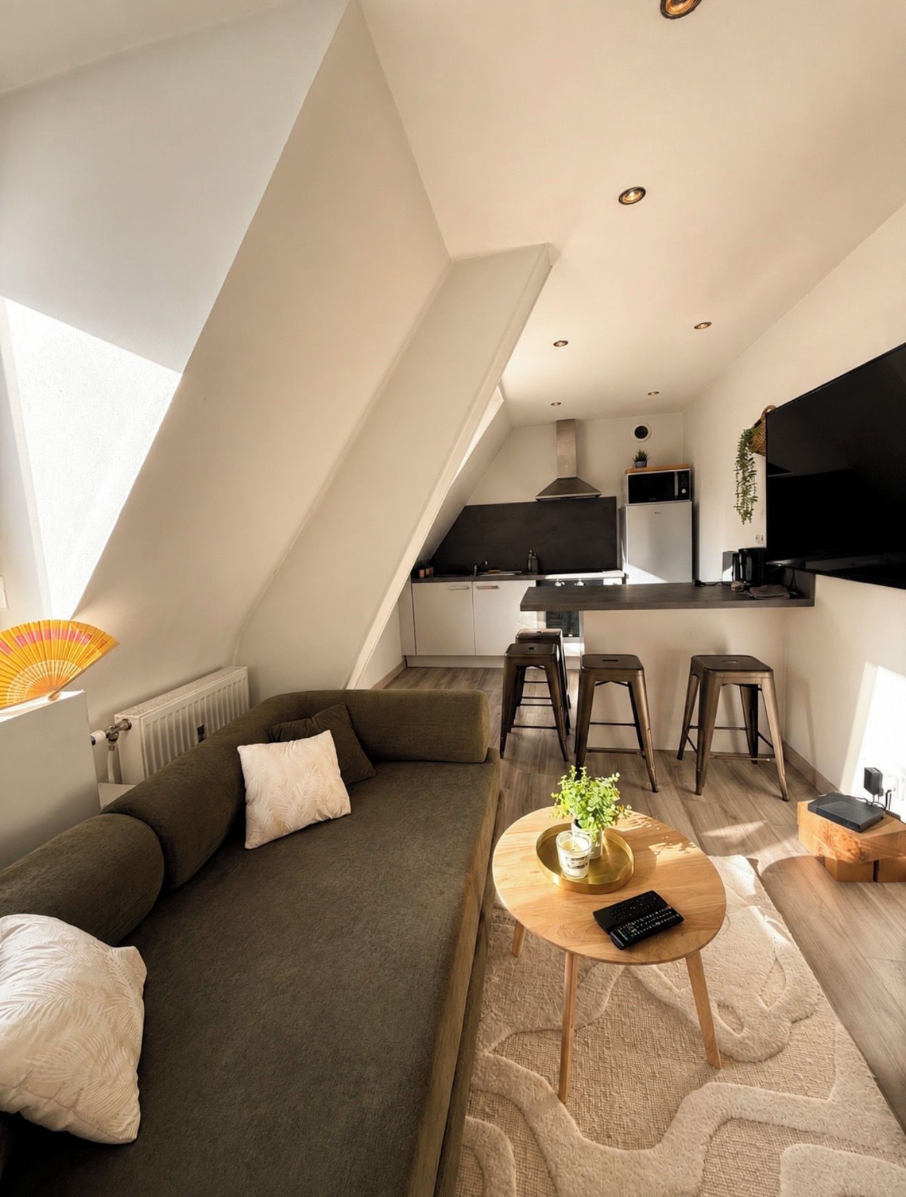 A modern loft apartment with a kitchen, dining area, and living space.