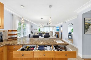 Eine moderne Küche mit Granit Arbeitsplatten, Holzschränken und einer eingebauten Schubladenkommode.