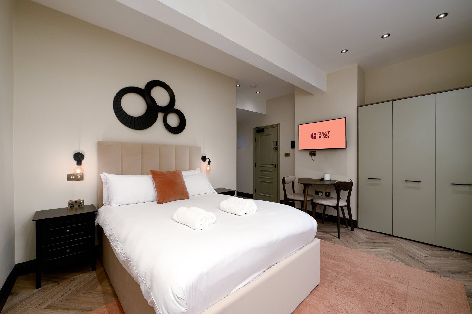 Une chambre d’hôtel avec un lit, un bureau, une télévision et une armoire.