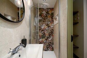 A bathroom with a shower, a sink, and a mirror. - GuestReady - Delightful retreat in Euston (London)