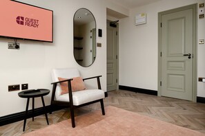 A hotel lobby with a chair, a small table, a mirror, and a door. - GuestReady - Delightful retreat in Euston (London)