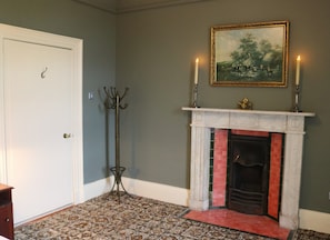 A room with a fireplace, a coat rack, and a door. - South Hill House, Historic Georgian manor with capacity for 52 guests (Delvin)