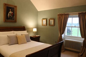 A hotel room with a bed, a nightstand, a lamp, a window with curtains, and two framed pictures on the wall. - South Hill House, Historic Georgian manor with capacity for 52 guests (Delvin)