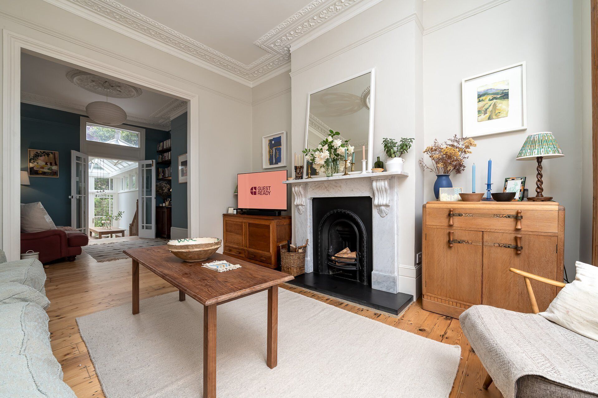 Una sala de estar con chimenea, televisor y estantería.