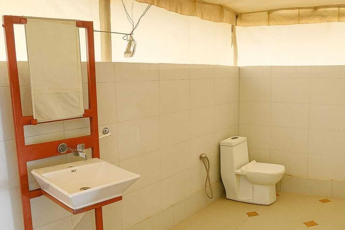 A bathroom with a white sink, a toilet, and a shower area.