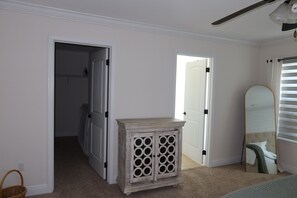 A bedroom with a wardrobe, a mirror, and a door leading to another room. - 3-bedroom house in inlet beach with private backyard (Panama City)