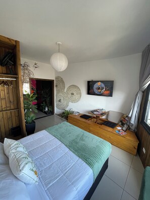 A bedroom with a bed, a wooden bench, a desk, and a potted plant. - Ryokan - More than just lodging, a sensory immersion. 3 minutes from Praça da Liberdade (Liberty Square). (São Paulo)