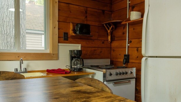 Une cuisine équipée d’un plan de travail en bois, d’une cuisinière, d’une machine à café et d’un réfrigérateur.