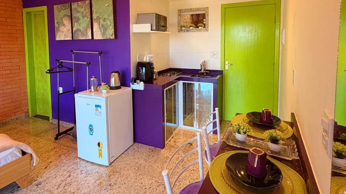Cocina pequeña equipada con refrigerador, microondas y lavamanos.