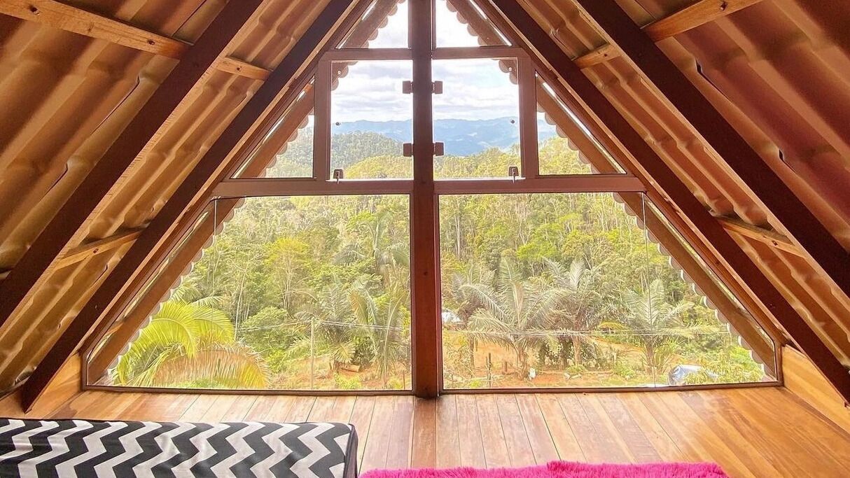Una habitación con un ventanal que ofrece vistas a un paisaje boscoso.