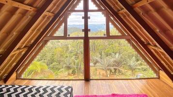 Una habitación con un ventanal que ofrece vistas a un paisaje boscoso.