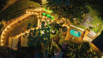 Eine Luftaufnahme eines Anwesens mit Schwimmbad, überdachter Terrasse und einem angelegten Garten.