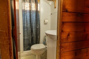 Ein Badezimmer mit Toilette, Waschbecken und Duschvorhang.