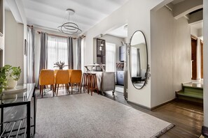 A modern kitchen with a dining area, a large mirror, and a staircase leading to another level. - Serene 3BR Spacious Apartment with Indoor Terrace & Bosphorus Views (istanbul)
