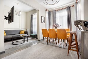 A modern living room with a sofa, coffee table, and dining area with chairs. - Serene 3BR Spacious Apartment with Indoor Terrace & Bosphorus Views (istanbul)