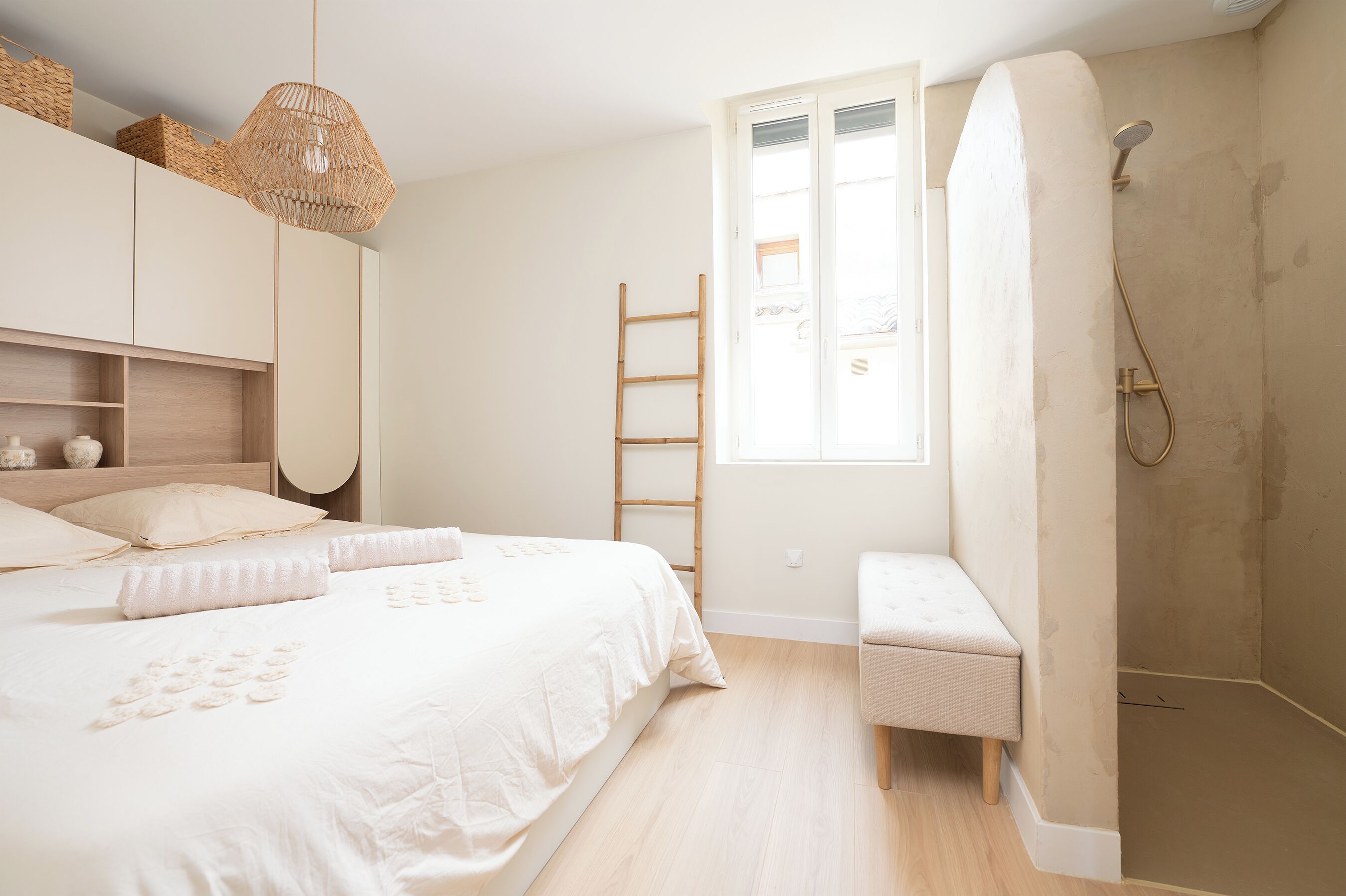Une chambre à coucher avec un lit, un banc, une échelle et une douche.