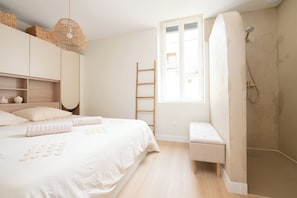 A bedroom with a bed, a bench, a ladder, and a shower. - Free parking • Downtown on foot • Air Conditioning (Albi)