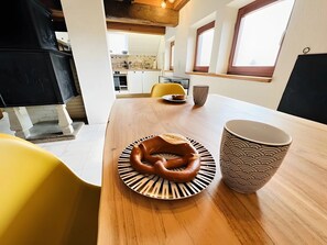 Eine moderne Küche mit einem Holztisch, einem gelben Stuhl und einer großen Tasse.