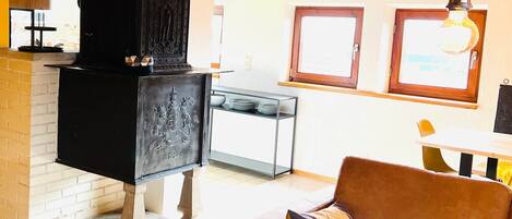 Ein gemütliches Wohnzimmer mit einer Couch, einem Kamin und einem Essbereich mit Tisch und Stühlen.