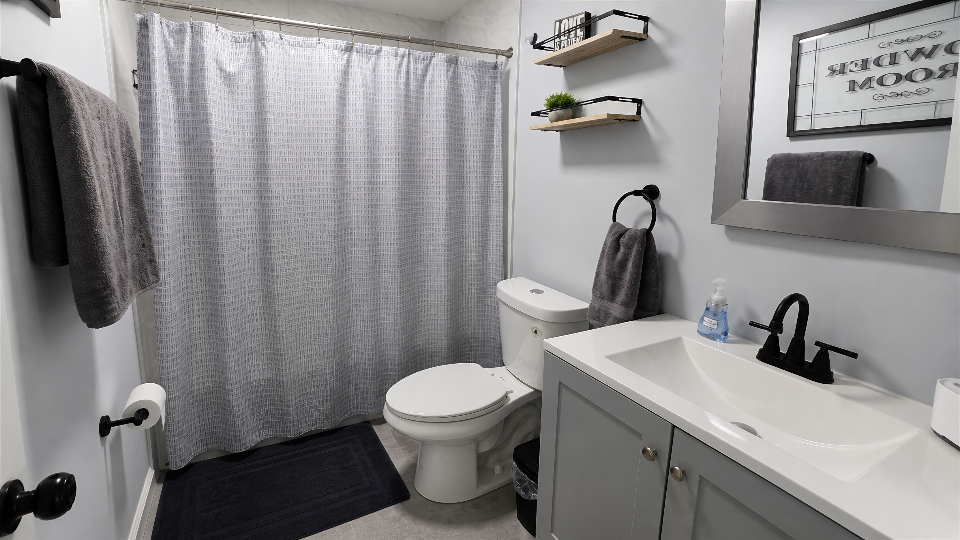 A bathroom with a toilet, sink, and shower curtain.