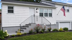 A two-story house with a front entrance, a staircase, and a flag. - BlueHaven House | Premium Executive Residence (East Haven)