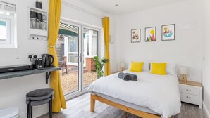A modern bedroom with a bed, bedside table, and a window with curtains.