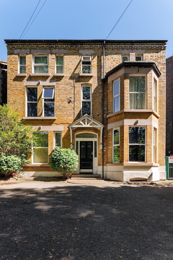 A two-story building with a symmetrical facade, a central entrance with a door, and a small porch area.