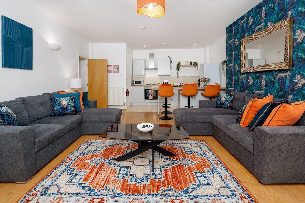 A modern living room with a sofa set, a coffee table, and a patterned rug.