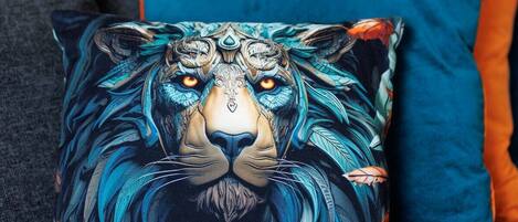 A sofa with a decorative pillow featuring a lion's face.