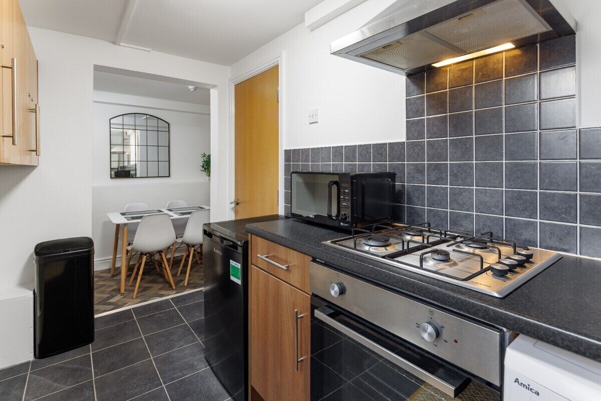 A compact kitchen with a gas stove, a dishwasher, and a microwave.