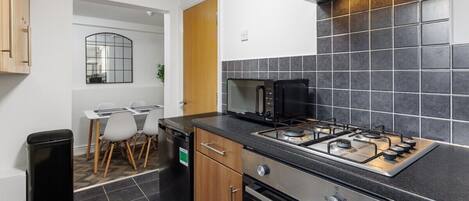 A compact kitchen with a gas stove, a dishwasher, and a microwave.