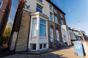 A residential building with a bay window, a bicycle parked outside, and a blue bin with the number 28. - Flatzy - Wavertree Flat Near Football Stadiums (Liverpool)