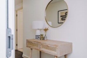 A wooden console table with a white lamp, a decorative vase, and a framed picture. - Flatzy - City Centre | 2 Bathrooms | Free Parking (Liverpool)