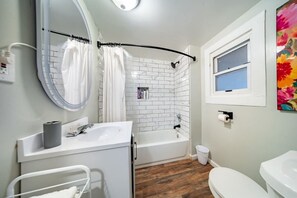 Une salle de bain avec un lavabo blanc, une baignoire et des toilettes.