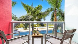 Ein Balkon mit Tisch, Stühlen und einer Weinflasche.
