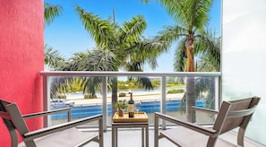 Ein Balkon mit Tisch, Stühlen und einer Weinflasche.