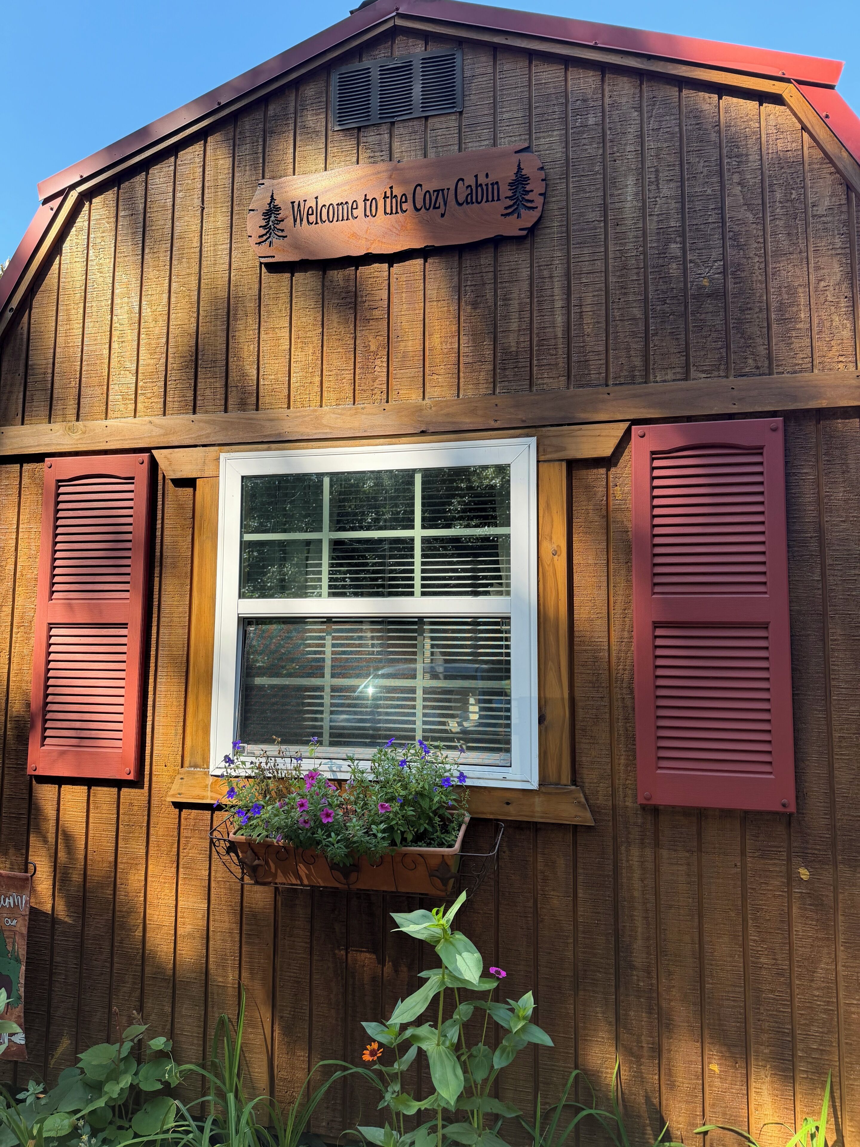 Una cabaña de madera con un cartel que dice 'Welcome to the Cozy Cabin'.