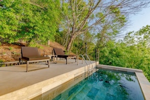 A swimming pool with lounge chairs and a stone wall. - Hottub w/Elite Ocean View! | Chef`s Kitchen | 3 Pools | Personal Concierge (Tamarindo)
