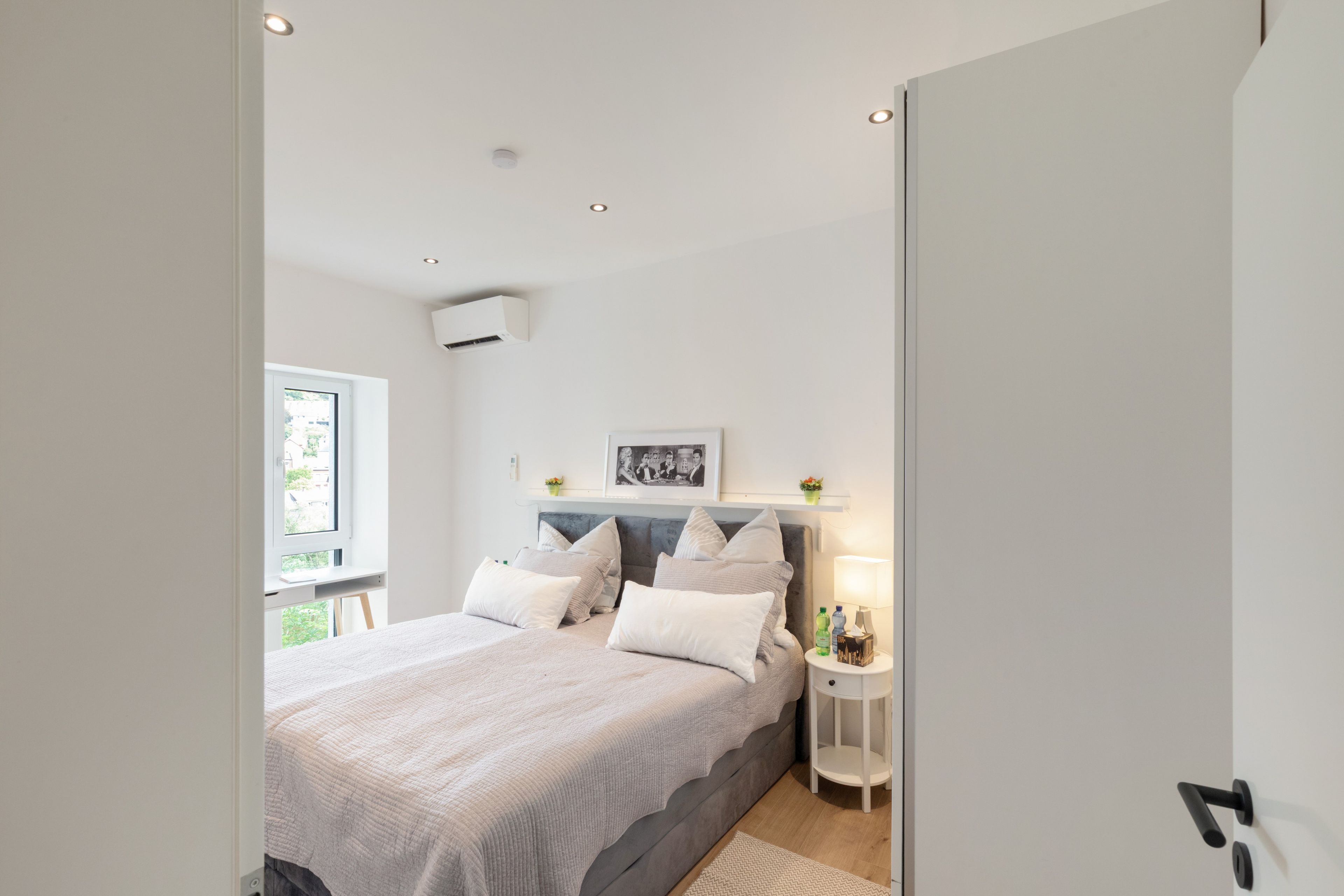 Ein Schlafzimmer mit einem Bett, einem Nachttisch und einem Fenster.