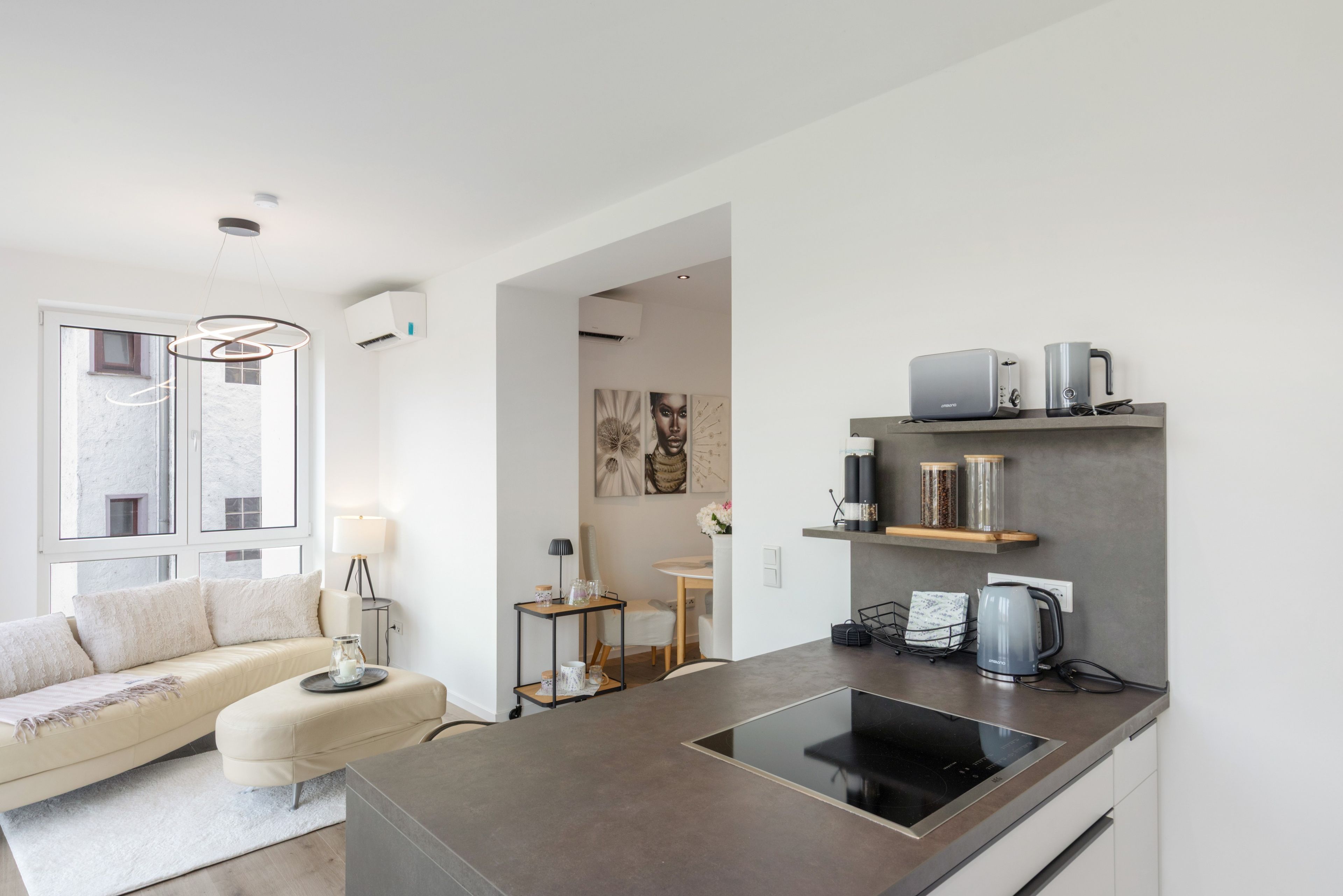 Eine moderne Küche mit eingebautem Induktionskochfeld, einer Kaffeemaschine und einem Toaster auf der Arbeitsfläche.