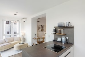A modern kitchen with a built-in induction cooktop, a coffee maker, and a toaster on the countertop.