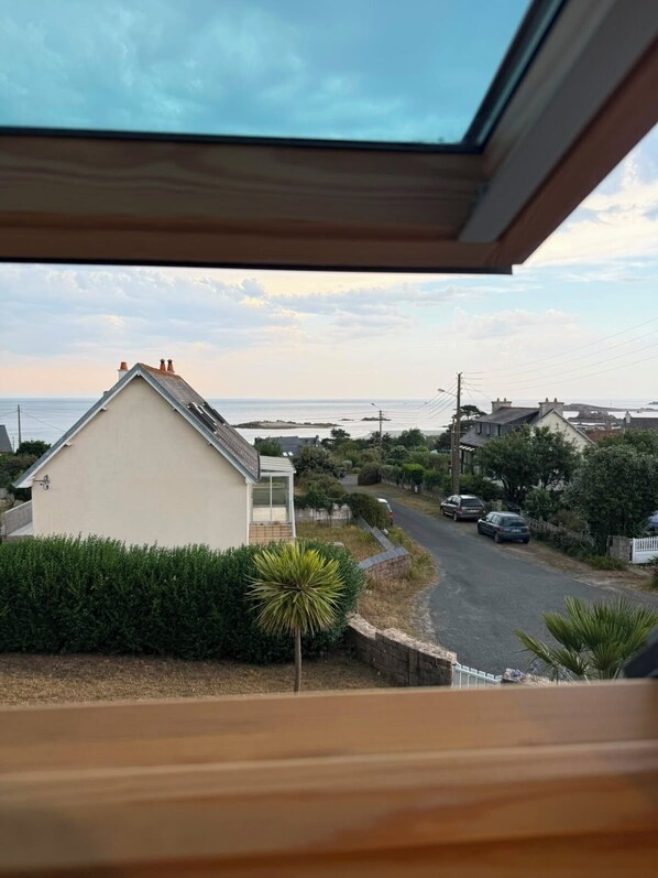 Una zona residencial costera con casas, una carretera y vista al mar.