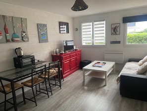 En kompakt bolig med tekøkken, spiseplads og siddeområde.