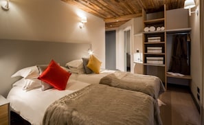 Ein Schlafzimmer mit zwei Betten, einem Kleiderschrank und einem Nachttisch.