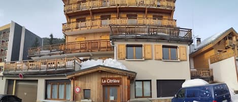 A multi-story building with a wooden facade, balconies, and a sign reading 'La Citriere'.