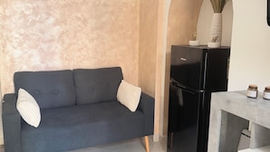 A modern living room with a dark grey sofa, a small table, and a black cabinet.