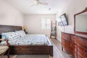 A bedroom with a bed, dresser, television, and a ceiling fan. - Enclosed Pool & Sauna Retreat Near Beaches (Fort Walton Beach)