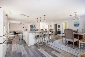 A modern kitchen with a central island, bar stools, and pendant lighting. - Enclosed Pool & Sauna Retreat Near Beaches (Fort Walton Beach)