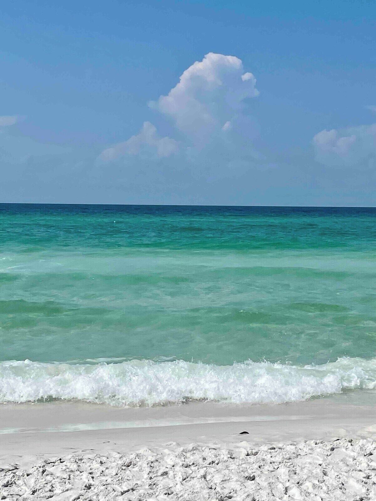 Een strand met helder turquoise water en een zandstrand.