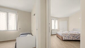 A bedroom with a bed, a wardrobe, and a window.